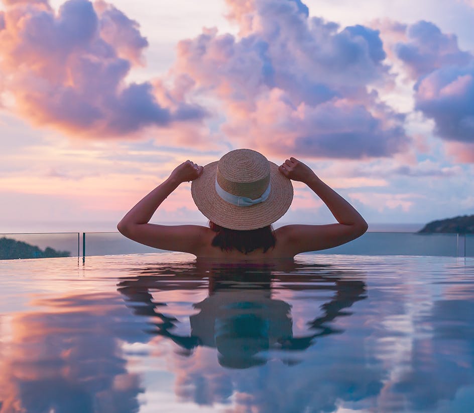 Woman looking at sunset while in a reflection pool