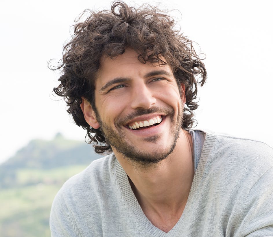 curly-haired man smiling