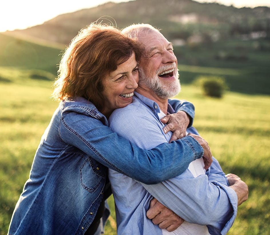 older man and woman hugging