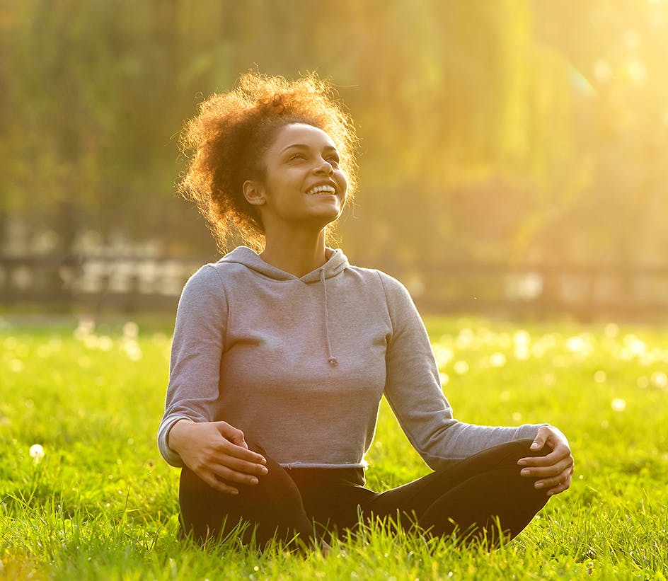 Woman sitting in a sunny and bright field