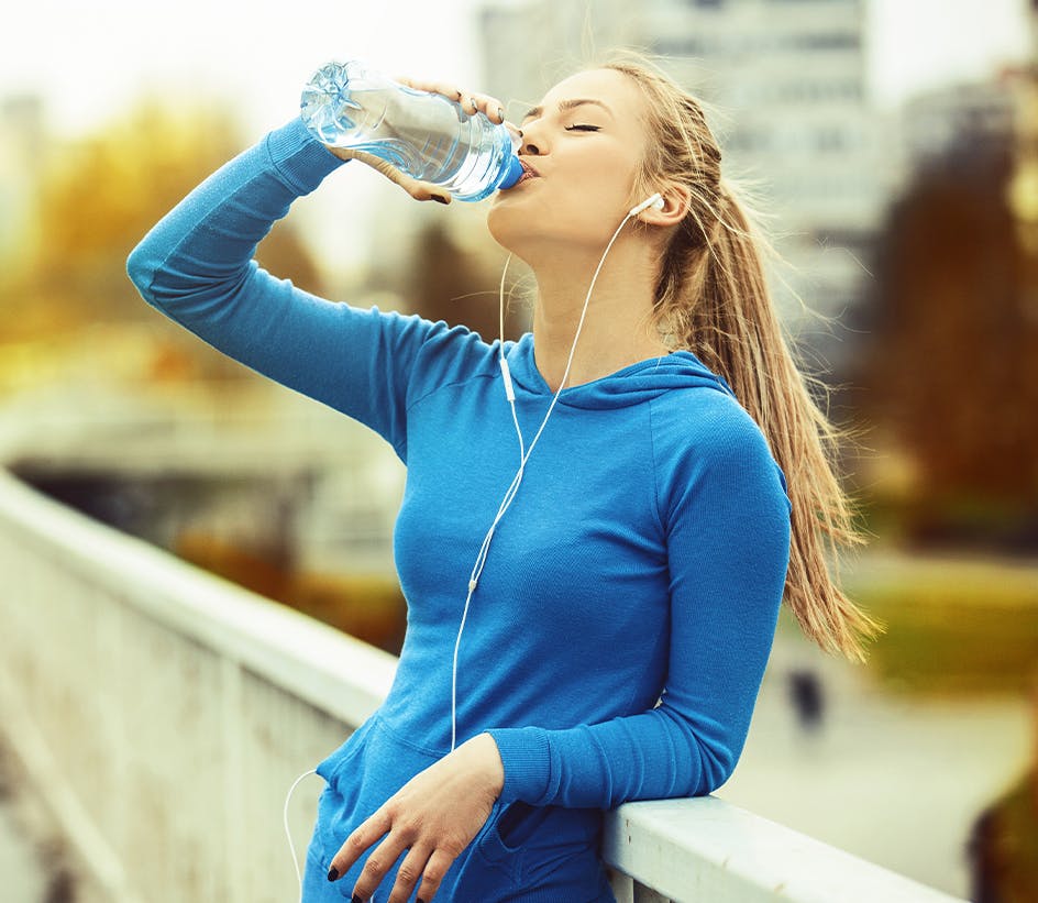 woman drinking water on a run