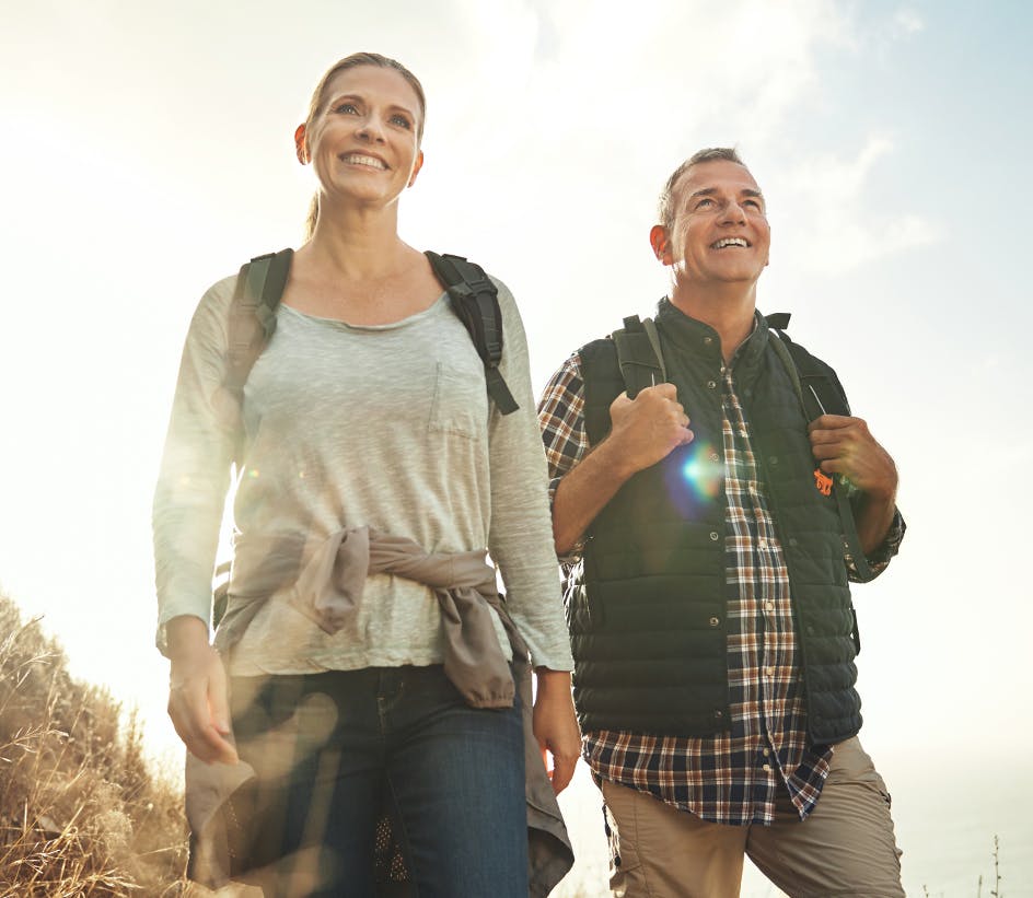 Husband and wife hiking with backpacks