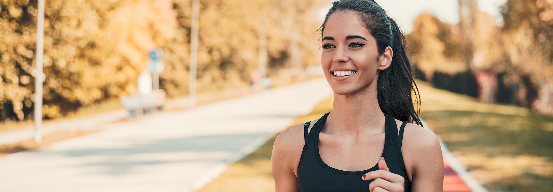 Smiling woman running through the park
