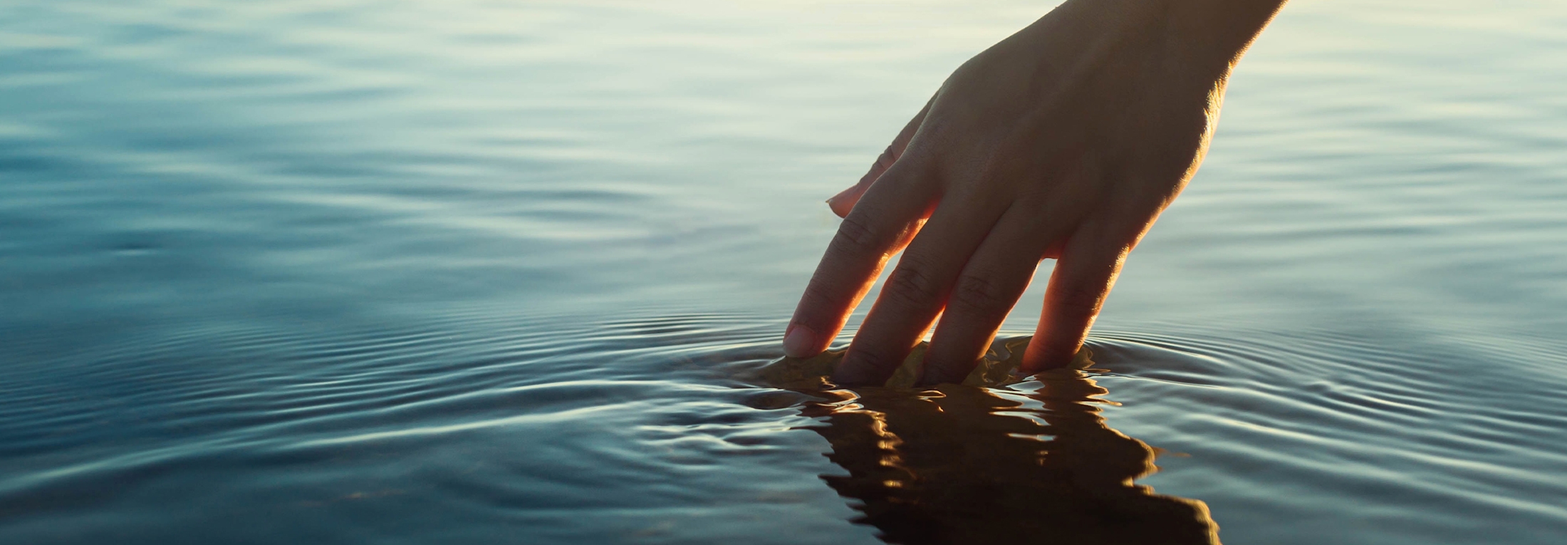 Person's hand touching water