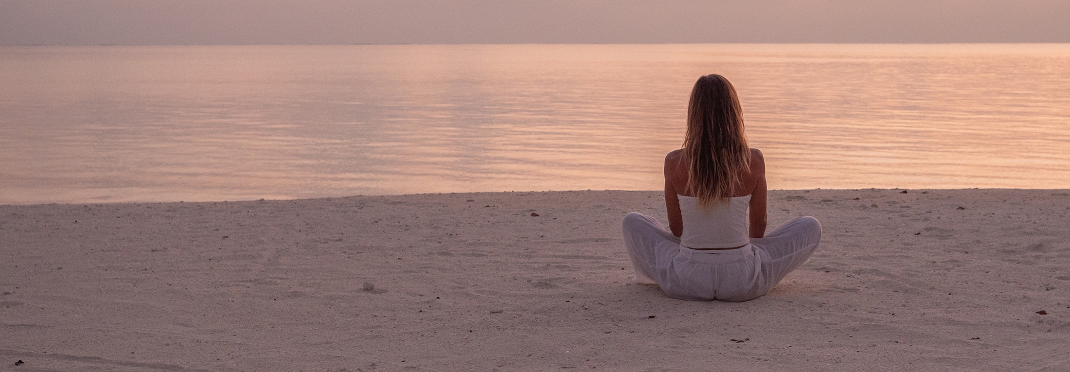 Woman meditating on a beach