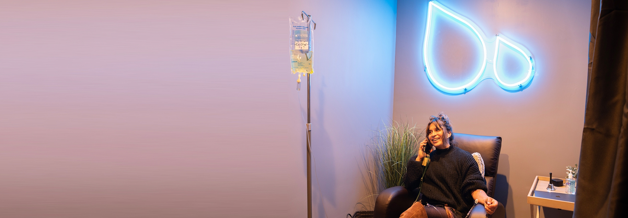 woman getting IV drip while on the phone