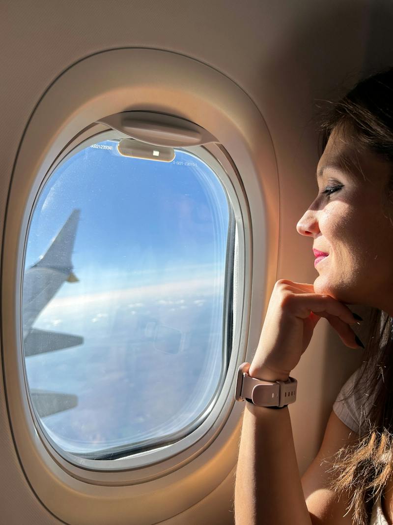 woman looking out airplane window