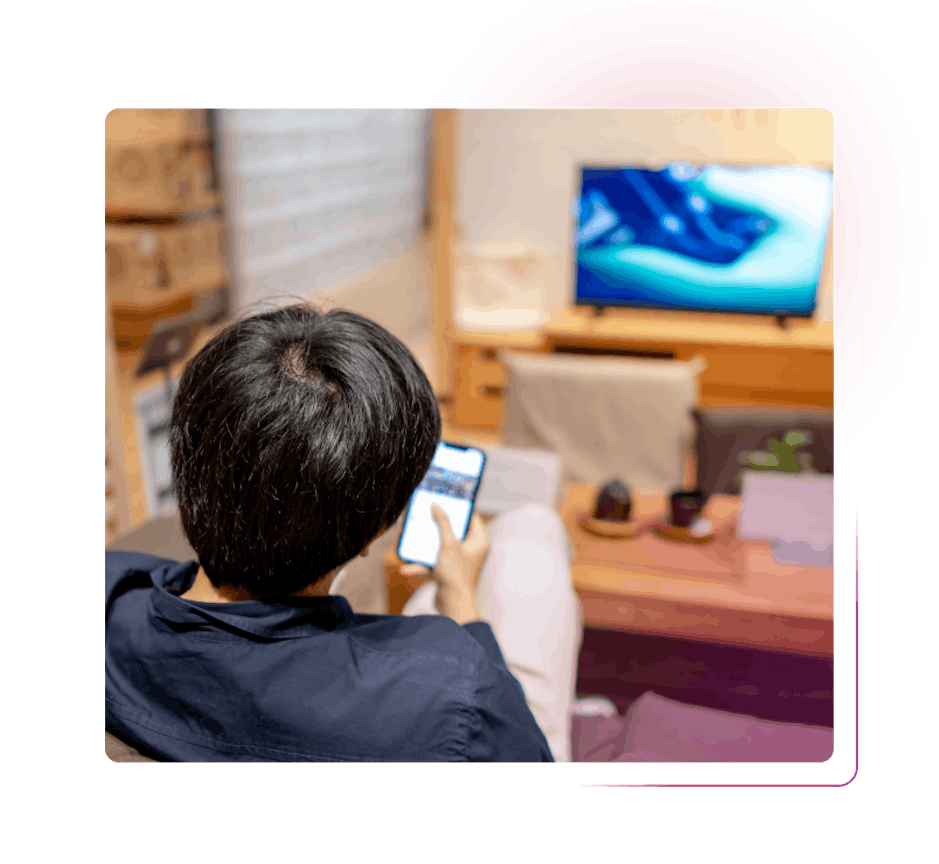Man using smartphone in front of TV
