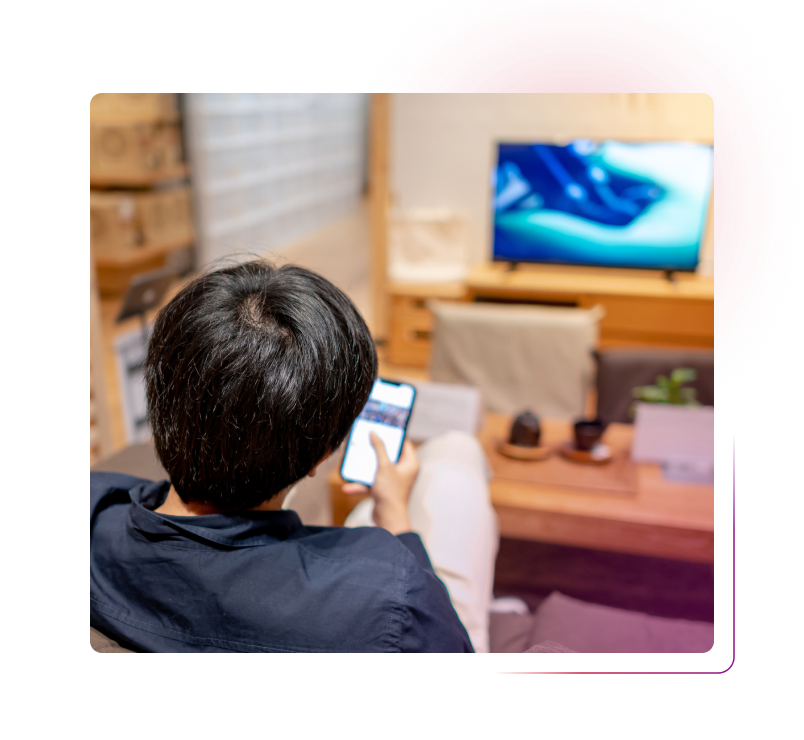 Man using smartphone in front of TV