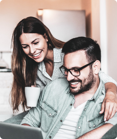 Woman with a cup and man using laptop