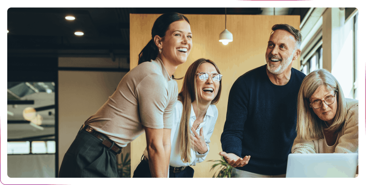 group of people smiling and laughing at the office