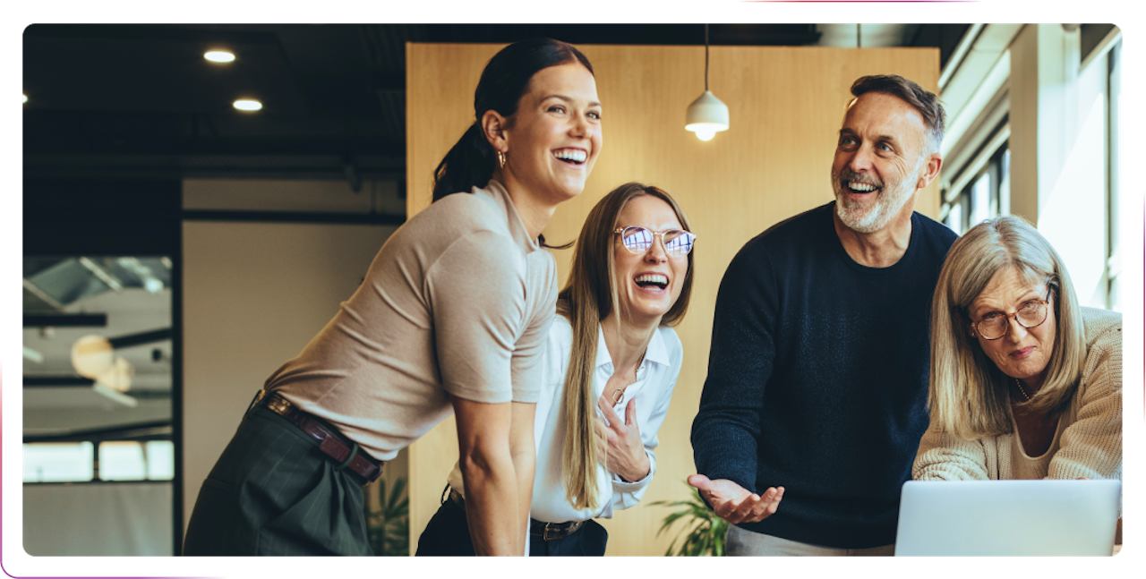 group of people smiling and laughing at the office