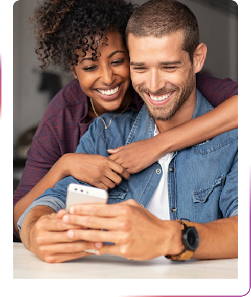 couple hugging and using a phone smiling