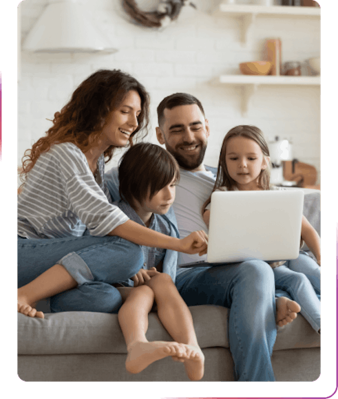 family using a laptop and smiling