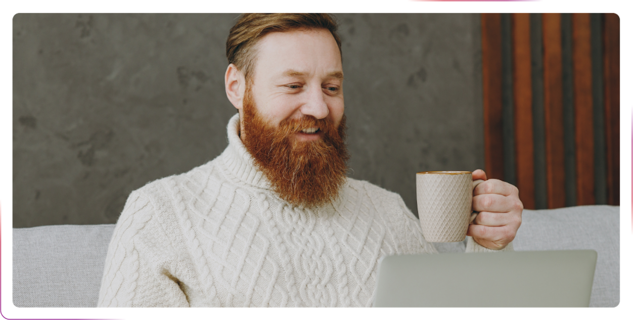 Young man drinking coffee and using a laptop
