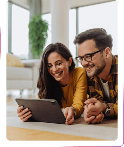 couple using a tablet and smiling