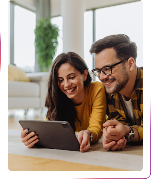 couple using a tablet and smiling