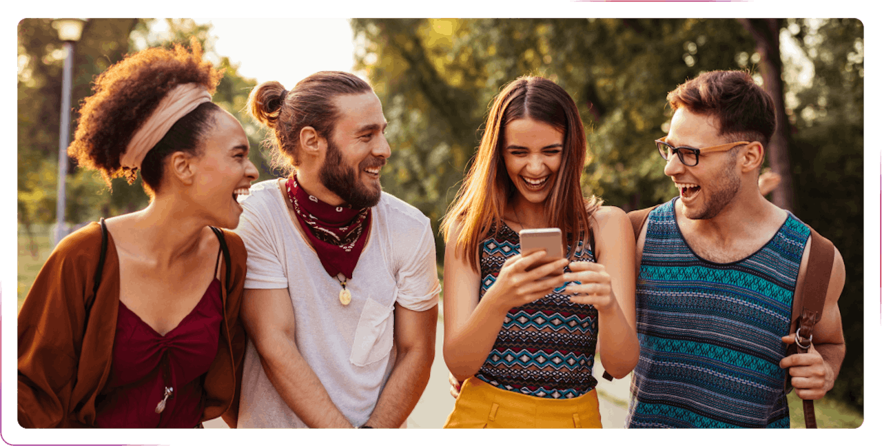 group of young people using phone and laughing