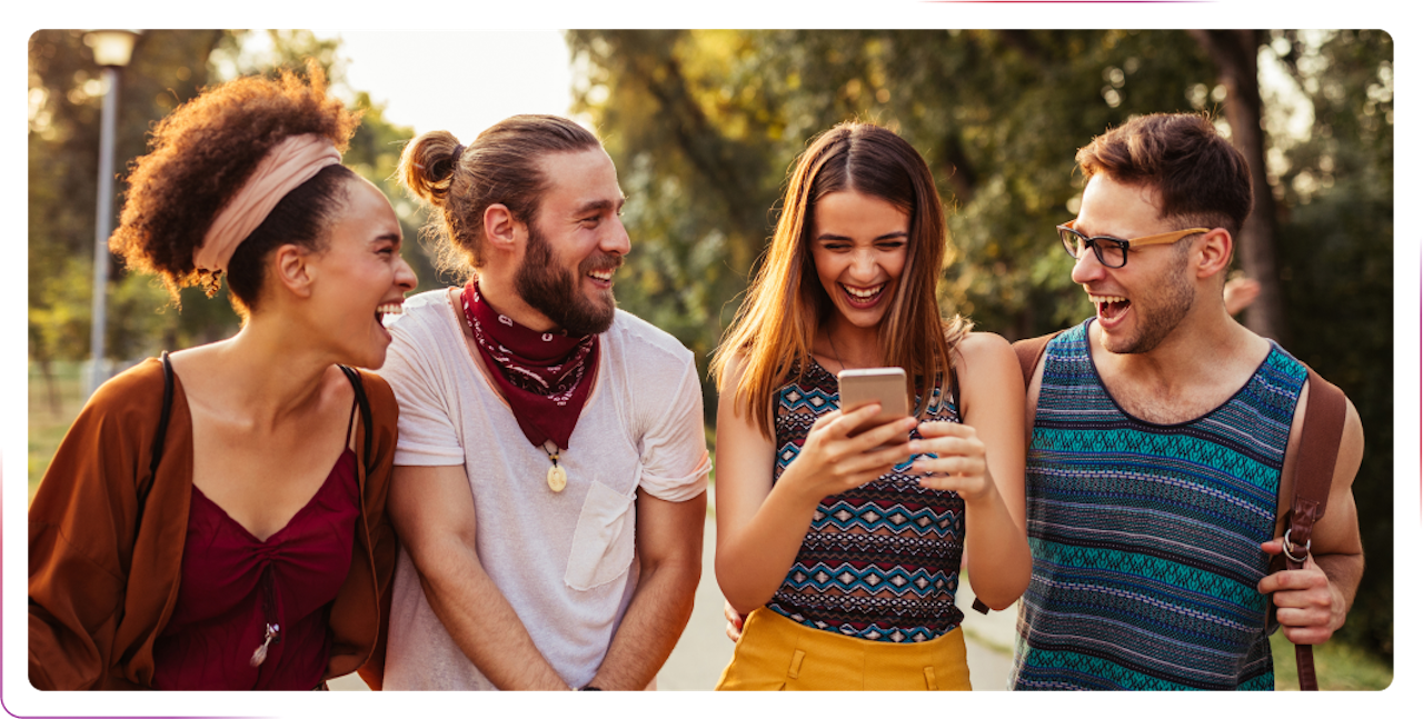 group of young people using phone and laughing