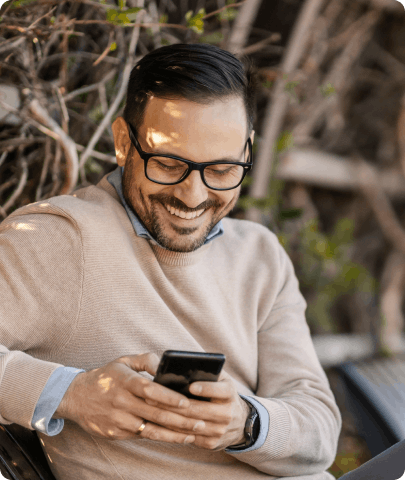 a young man smiling using a phone