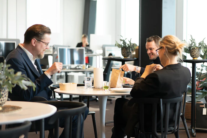Image of three employees having coffe together