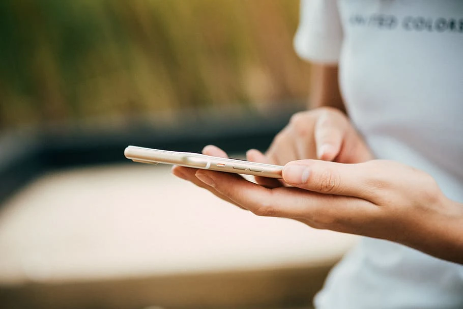 Close up on woman holding a cellphone with two both hands