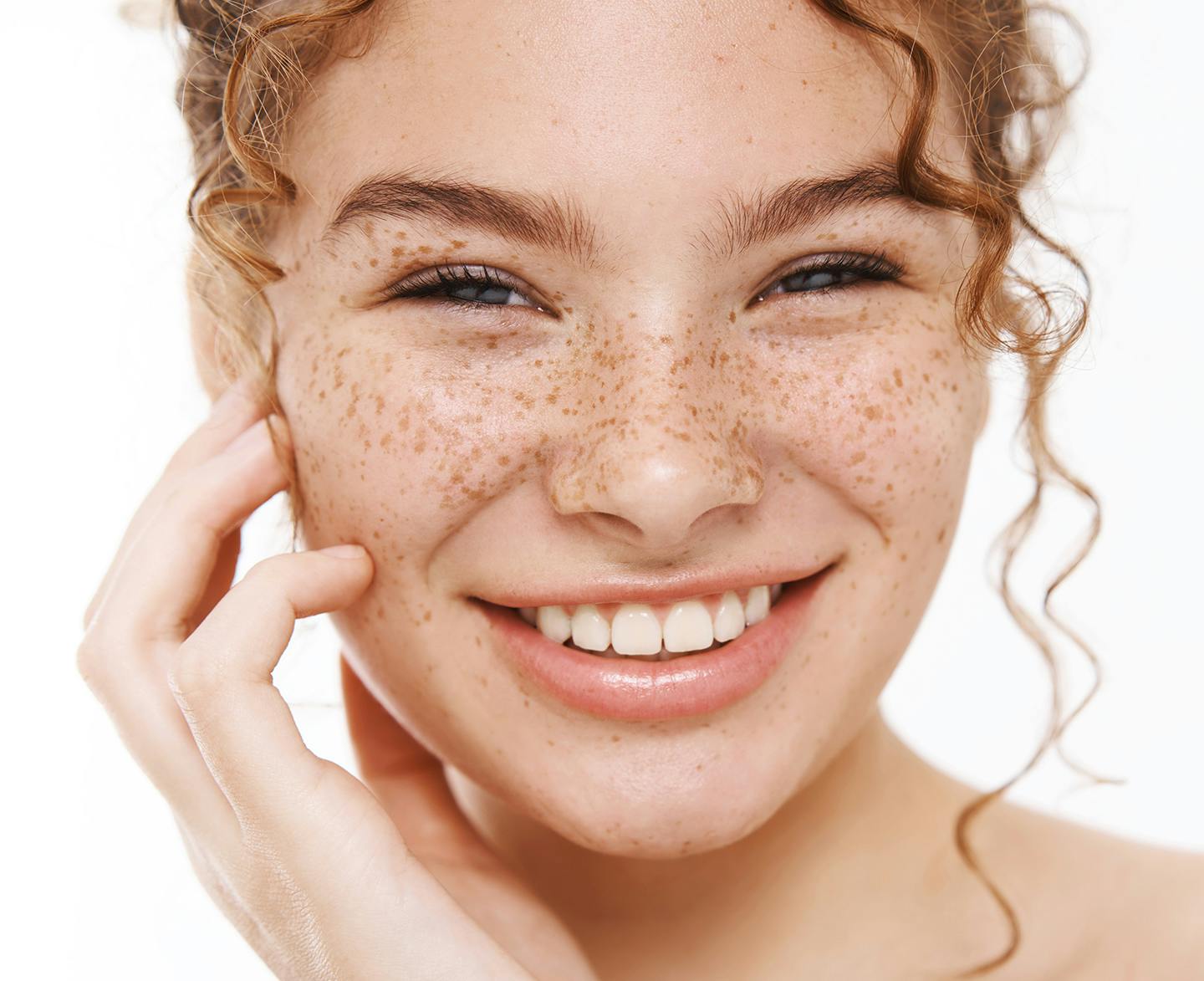 woman with freckles and curly hair smiling