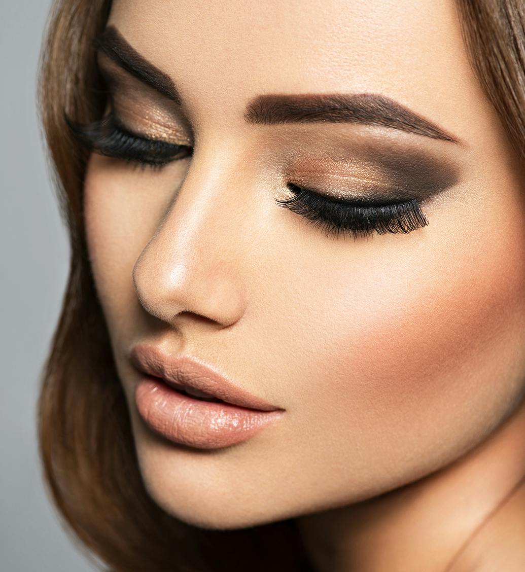 close up of a woman's face with lots of eye makeup on