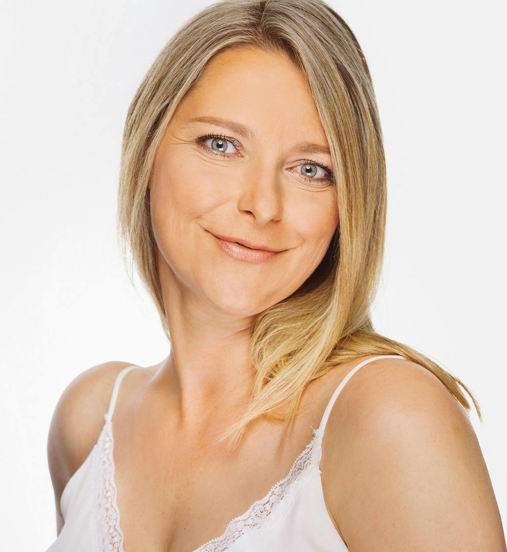 Woman smiling in a white tank top