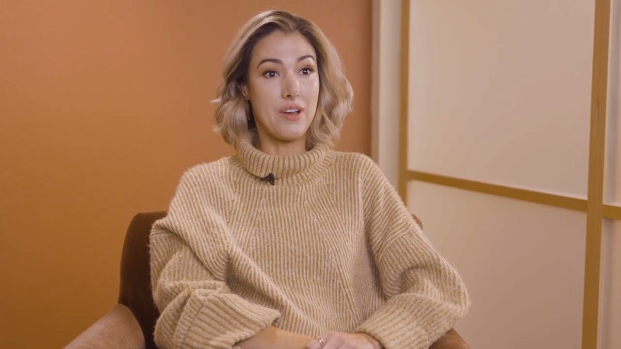 woman with a turtle neck on and a brown background