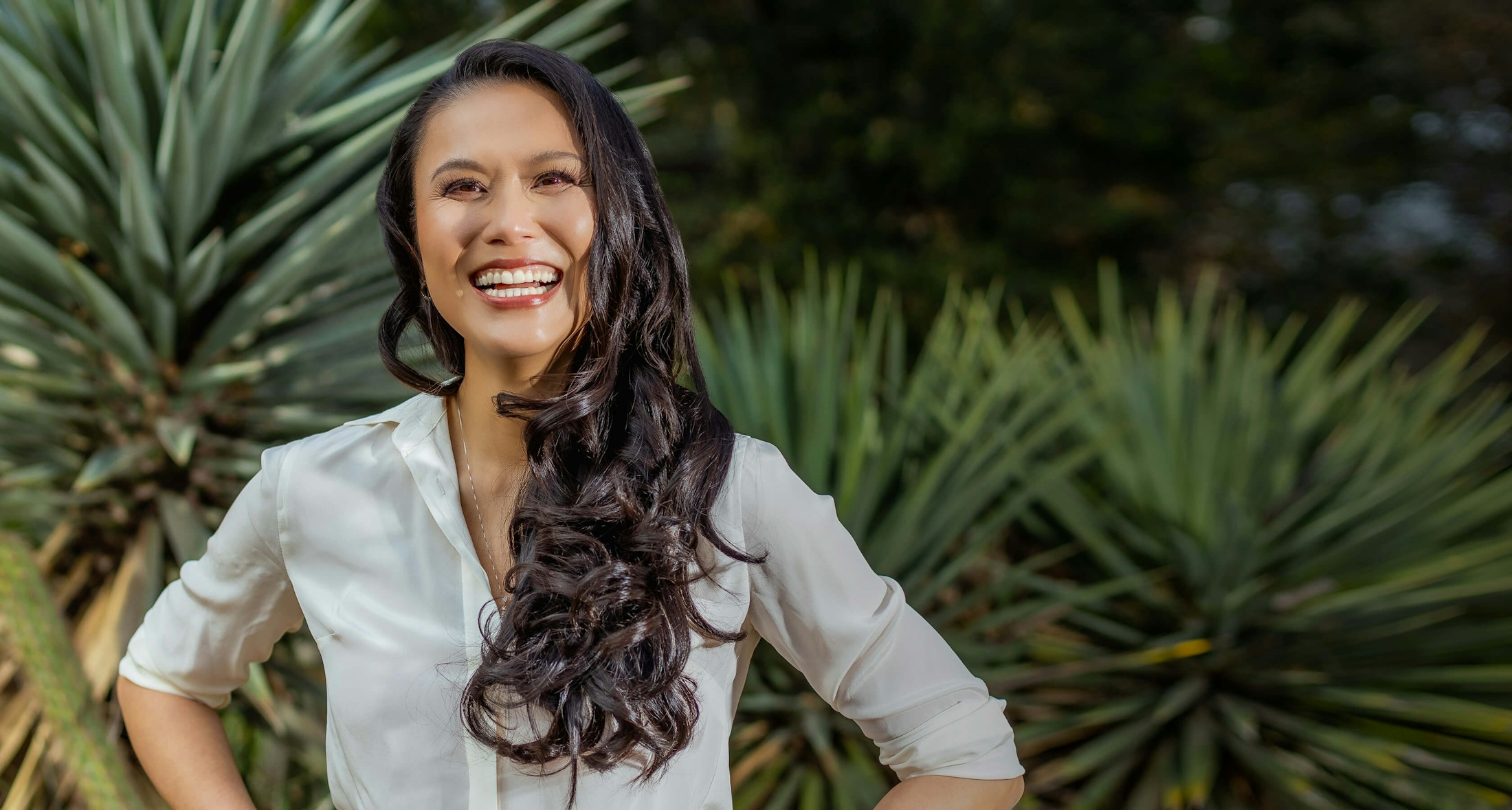 Dr. Graw smiling with green plants in the background