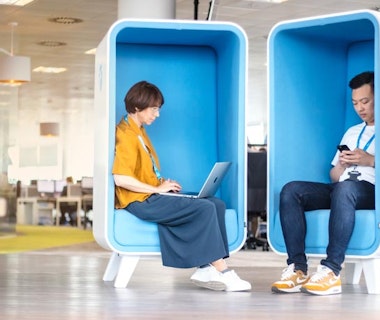 Office workers using laptops in a breakout area