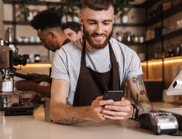 Peninsula Group Limited - Cafe worker checking his legal insurance policy on his phone