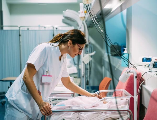 Peninsula Group Limited - Health care worker checking on a new born baby in a hospital room