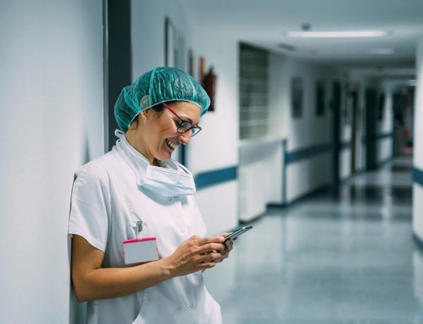Peninsula Group Limited - Healthcare worker checking their wellbeing software on their phone during a break
