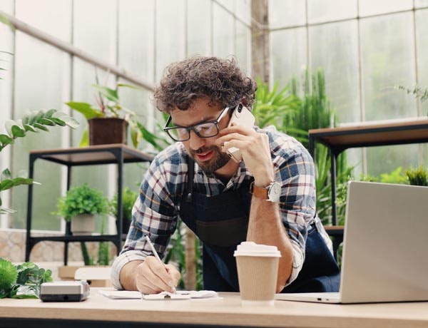 Peninsula Group Limited - Employer having a phone call with their legal advisor in a greenhouse setting