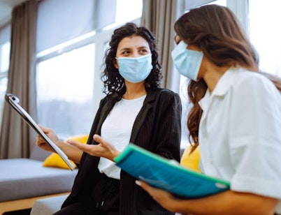 Peninsula Group Limited - Two workers discussing potential safety issues while wearing face masks