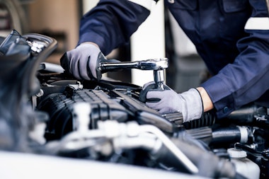 Peninsula Group Limited - A mechanic making adjustments to an engine