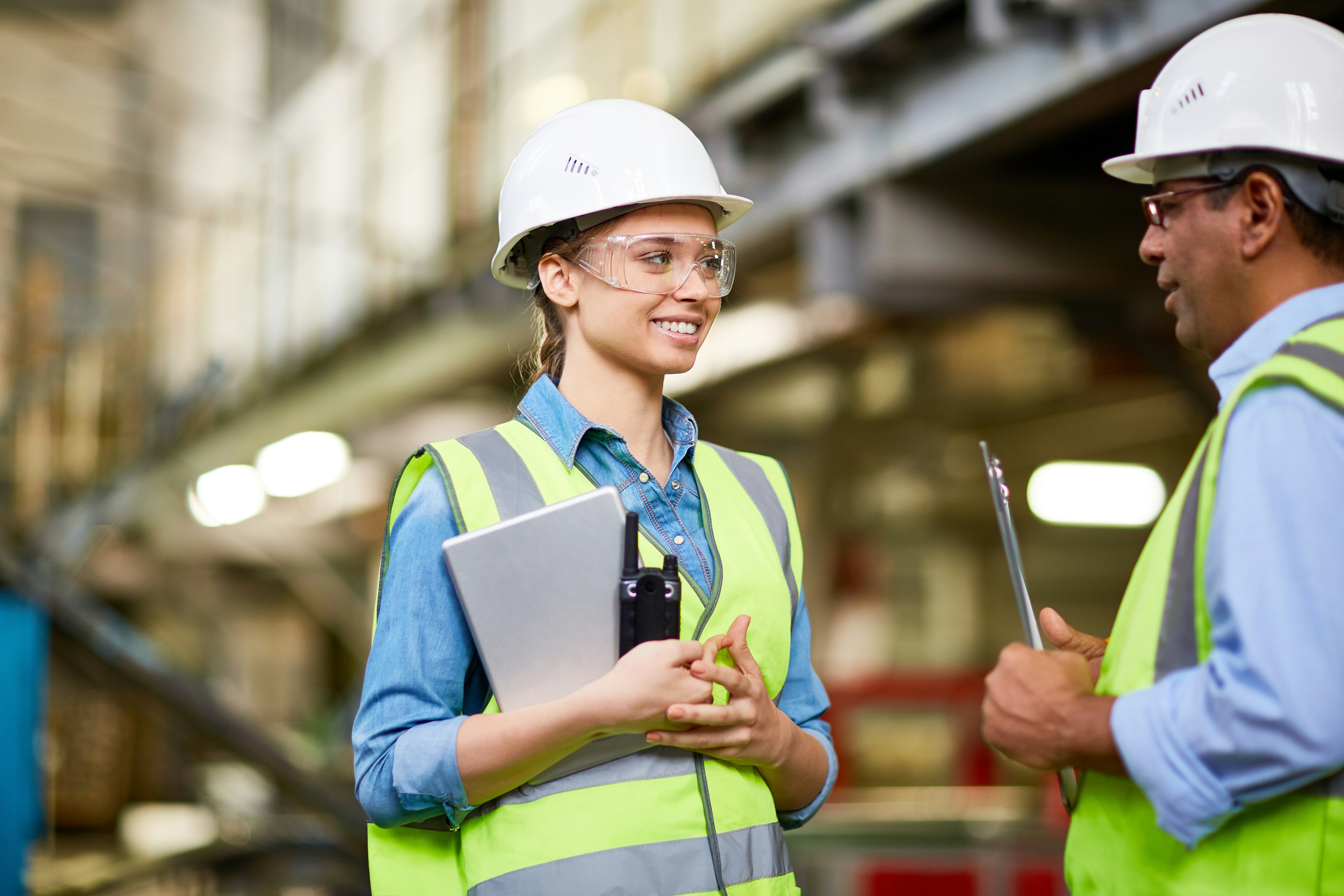 Peninsula Group Limited - A workers in a full PPE talking a colleague