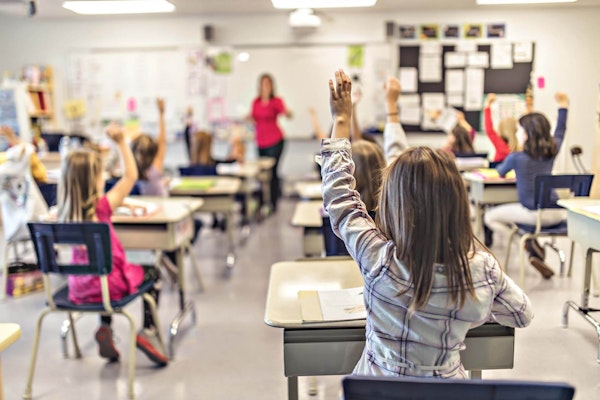 Hands raised in a classroom of students