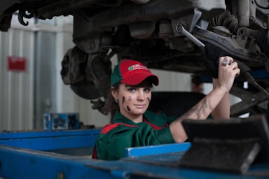 mechanic working on the underside of a car