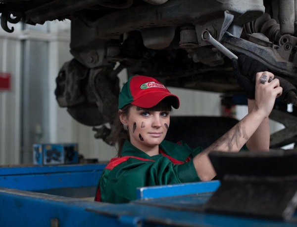 mechanic working on the underside of a car