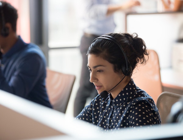 Woman working at a desk speaking into a headset