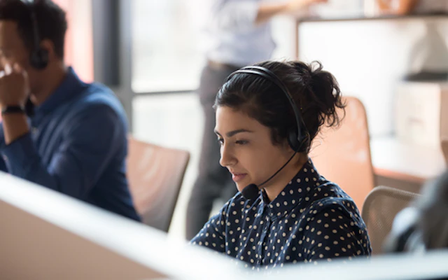 Woman working at a desk speaking into a headset