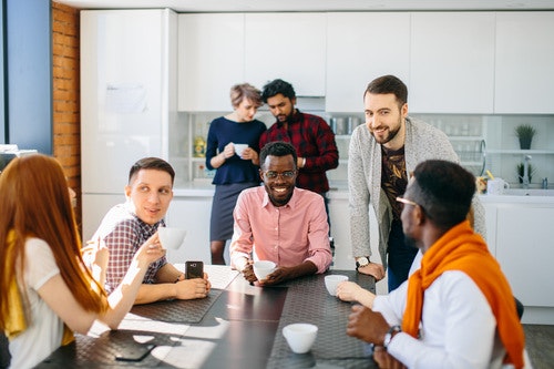 Employees chatting around a breakroom table