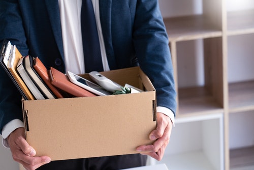 a person wearing a suit with a box of their belongings