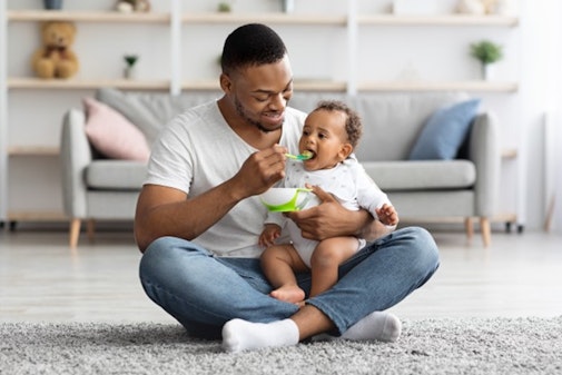 Someone feeding their baby some food.