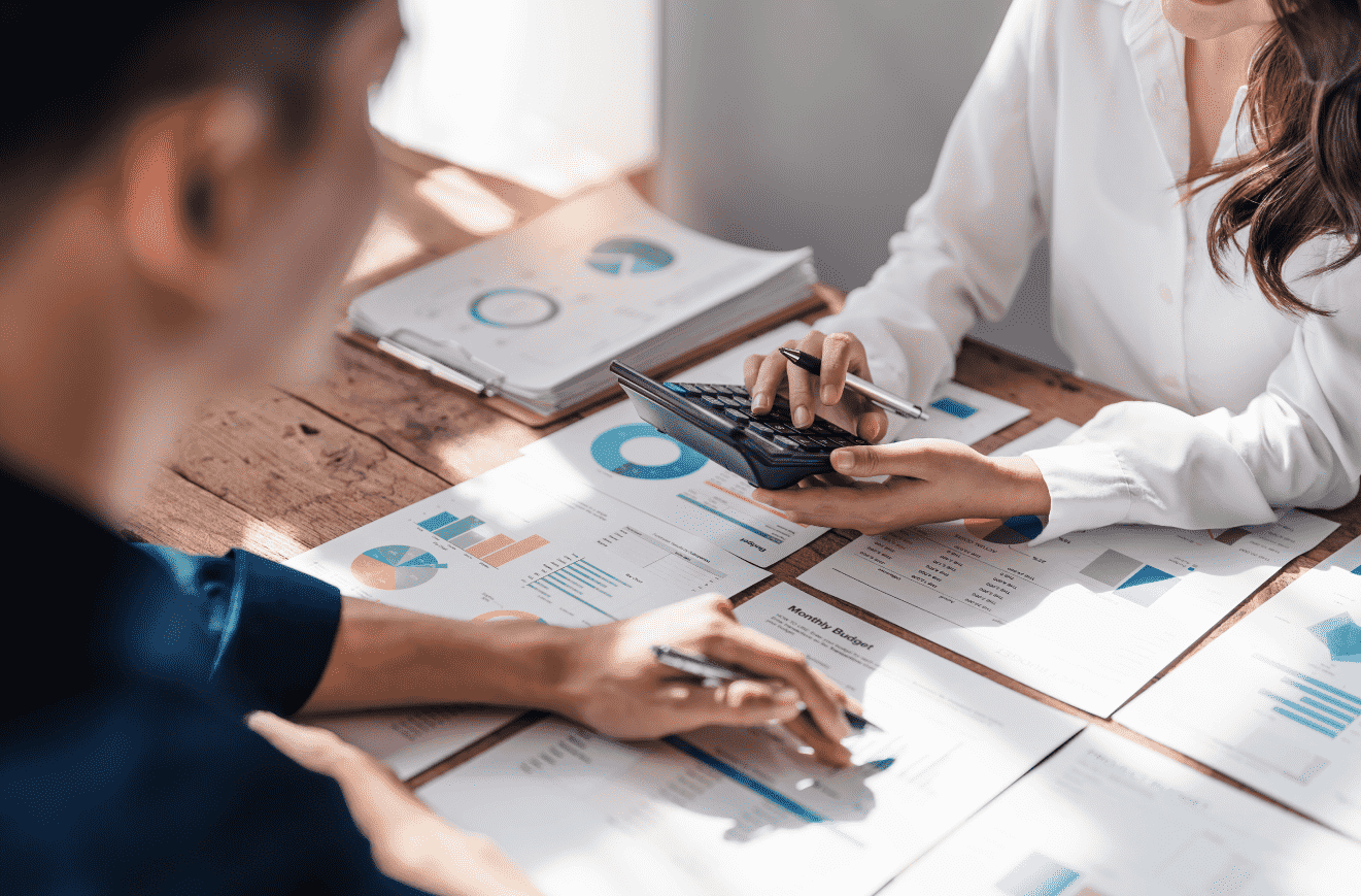 Two people at a desk reviewing financial documents