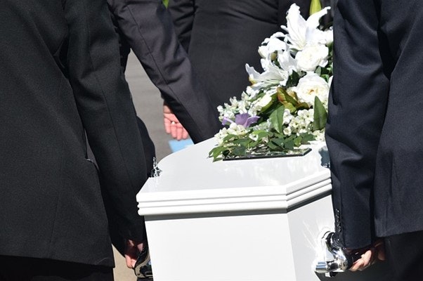 People carrying a coffin to a funeral.