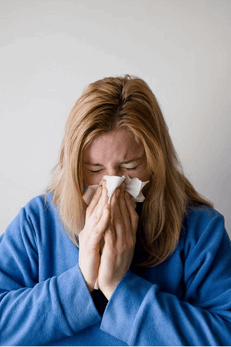 Someone who is ill blowing their nose.